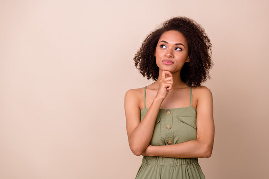Photo of clever dreamy lady arm touch face has question doubt idea unsure look empty space isolated on beige color background