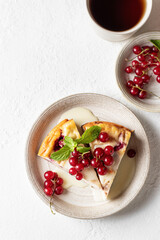 Cottage cheese casserole with fresh summer berries and tea cup on white table for healthy breakfast. Top view, text space
