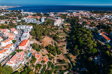 Aerial drone view of Ribeira das Vinhas hiking trail in Cascais, Portugal with Cascais Bay visible in the background