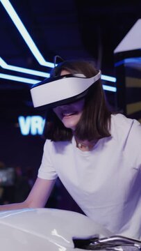 European woman in virtual reality glasses controls a motorcycle