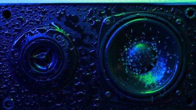 Music speaker in water drops Music speaker close-up blue and green color. Lighting to the beat of the music