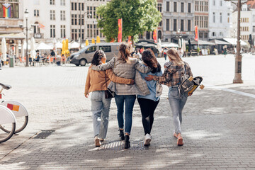female friends young ladies walking embrac in city center