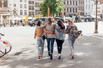 Crédence de cuisine en verre imprimé Anvers female friends young ladies walking embrac in city center