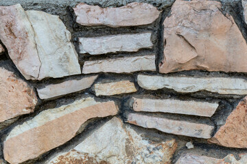 The texture of the stone wall. Stone wall closeup, background or texture. Part of a large stone for background or texture