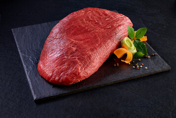 roher Rinderbraten mit Gemüse und Gewürzen auf Schiefer