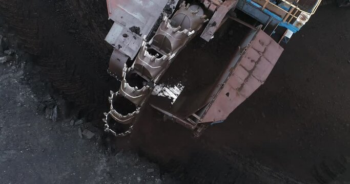 Huge industrial machine. Giant rotary bucket. Coal mining. Mining. Development of rock with a large excavator. Mining quarry. Energy industry. The work of a huge mechanism. Giant bucket wheel.