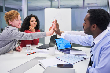 Multicultural business startup team at the high five