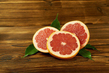 Slices of fresh grapefruit on a wooden background. Beautiful photo wallpaper.