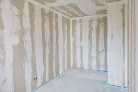 Filler work on the wall and ceiling in a room with a corner