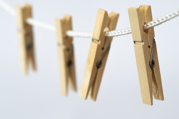 Den Helder, Netherlands. July 2022. Wooden clothes pegs on a white background. Selective focus.