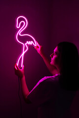 Beautiful girl with neon signs. Pink neon flamingo. Trendy style. Neon sign. Custom neon. Home decor. 