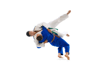 Studio shot of two men, professional judo athletes training isolated over white background. Throwing exercises