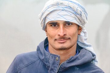 a laborer is wearing a turbine and working at a construction site 