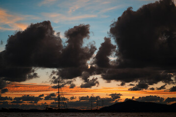 Dramatic landscape with sunset on the sea shore. Beautiful cloudy sky.