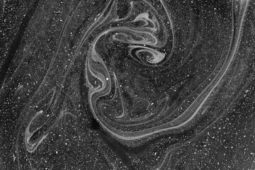 Abstract dark grey drawing with paints on the water. Abstract background. Ebru technique. Selective focus.