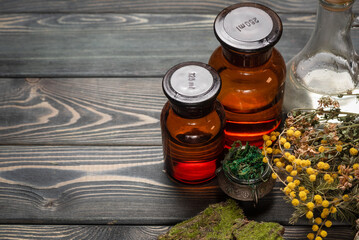 Herbal medicine concept background. Dry natural ingredients and remedy bottle on the wooden table...