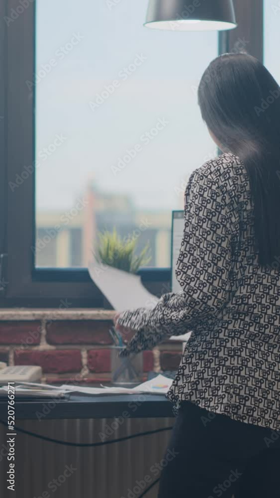Poster vertical video: close up of employee working with documents and computer to plan business project in