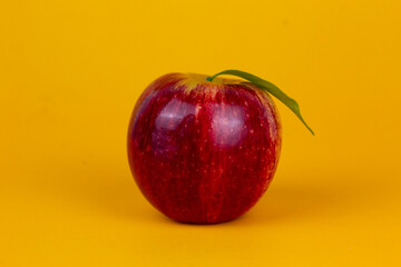 A red apples isolated on yellow background. Organic red apple fruit used for healthy fruit concept  with clipping path and full depth of field