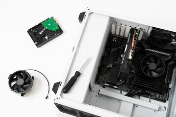 Close-up picture of desktop computer disassembled into parts for repair with screwdriver. Parts and...