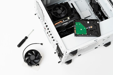 Close-up picture of desktop computer disassembled into parts for repair with screwdriver. Parts and components for modern computer. Technology concept.