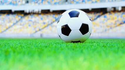 leather soccer ball on green fresh grass at stadium