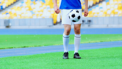 cropped view of sportive football player bouncing soccer ball with legs