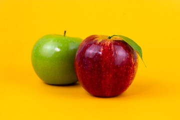 Red and green apples isolated on yellow background. Two fresh apples fruits usedd for healthy food concept and for diet apples design