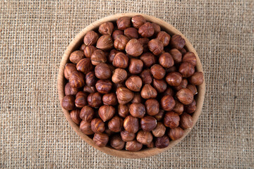  View of a bowl full of hazelnuts on burlap