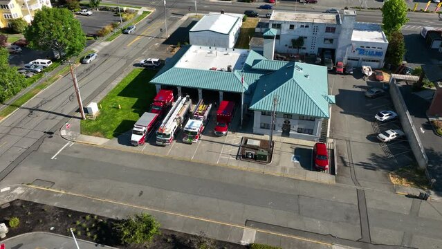 Drone view of multiple firefighter vehicles in front of their home base.
