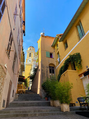 Villefranche-sur-Mer, France, October 2, 2021: The Rue de l'Église Street with the Saint Michel's Church in the background, French Riviera.