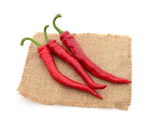Three red pepper on burlap.