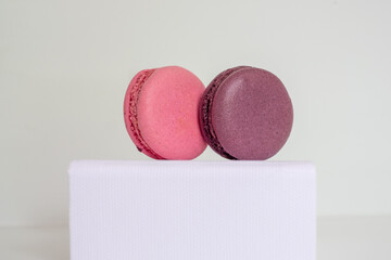 Close-up of appetizing colorful macaroons on white box on light background.