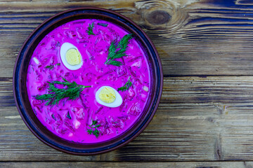 Plate with beet soup on a wooden table. Top view