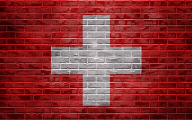 Country national flag on a brick wall, background and texture.Switzerland flag.