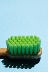 Close up of plastic green toothbrush on blue . Free copy space.