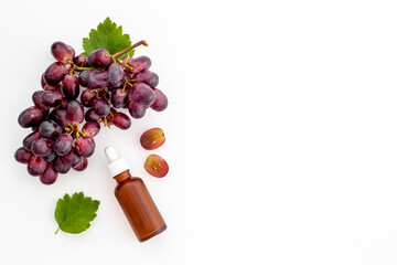 Grape seed essential oil with bunch of grapes. Eco cosmetic product