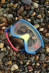 swimming mask is not new on sea stones soft light close-up