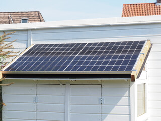 Mini photovoltaic system on a garden shed. Electricity self-sufficiency or energy transition concept