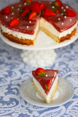Piece of homemade holiday strawberry cake with cottage cheese creamst and strawberry confit decorated with fresh berries