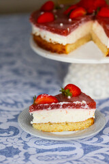 Piece of homemade holiday strawberry cake with cottage cheese creamst and strawberry confit decorated with fresh berries