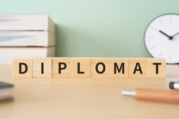 外交官のイメージ｜「DIPLOMAT」と書かれたブロックが置かれたデスク

