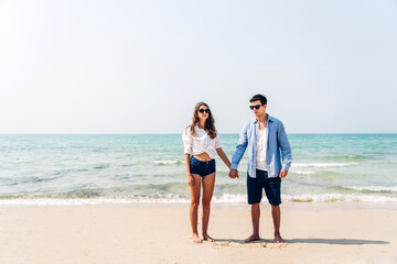 Vacation romantic love young happy smile couple in honeymoon travel holiday trip standing on sand at blue sky sea beach having fun and relaxing together on tropical beach.Summer travel - Powered by Adobe