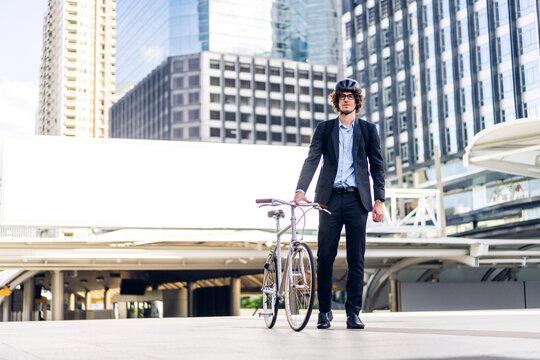 Portrait Of Hipster Handsome Businessman In Suit With Backpack Walk And Hold Riding Bicycle On The Street City Way Go To Work.business Travel Transport Bike Concept