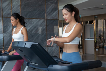 Fototapeta premium Sporty asia woman exercising on multistation at gym for arm and shoulders muscles. Fitness exercising in gym at condo