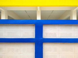 Background abstract blue and yellow line pattern of concrete block wall in front of white building