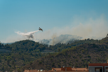 A firefighters airplane is seen discharging water over fires in the Catalonia region countryside,...