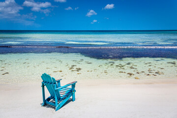 Idyllic beach with rustic adirondack chair in Aruba, Dutch Antilles
