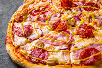 Pizza with Mozzarella cheese, backon, ham, tomato sauce, pepper, sausage. Italian pizza on Dark grey black slate background