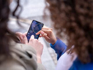 UK, Close-up of two women looking at map on smart phone