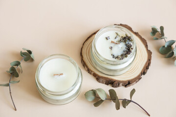 Two candmade candles from paraffin and soy wax in glass with wooden wick and dry herbal isolated on...
